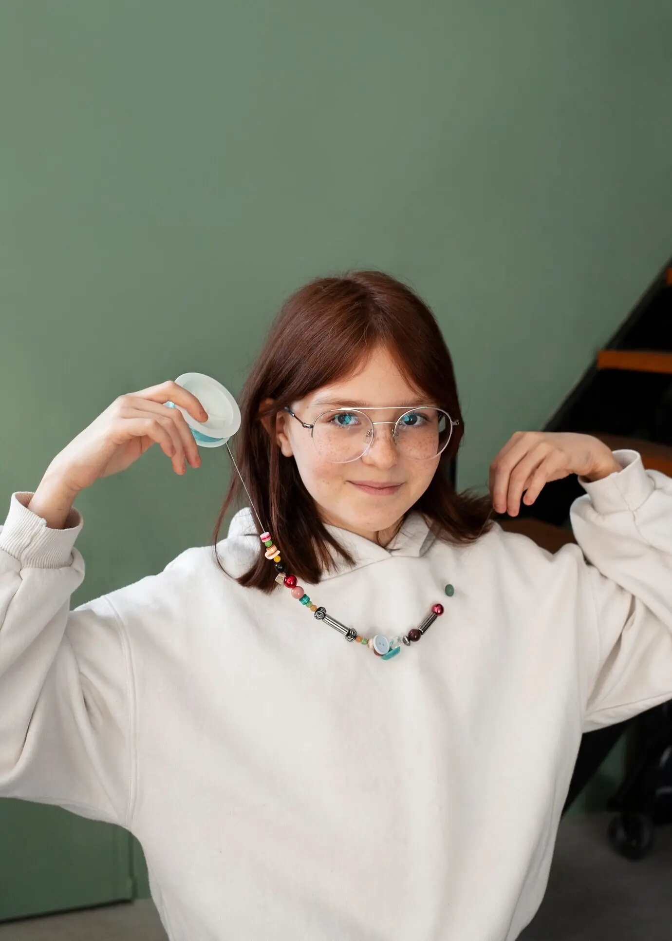 Junges Mädchen mit einer Halskette für ein Upcycling-Projekt